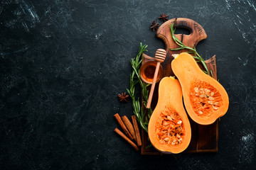 Fresh pumpkin with honey, healthy food. On a black stone background. Top view. Free copy space.
