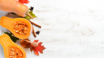 Fresh pumpkin with honey on white wooden background. Autumn food. Top view. Free copy space.