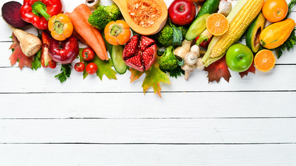 Fresh autumn vegetables and fruits on white wooden background. Healthy food. Top view. Free copy space.