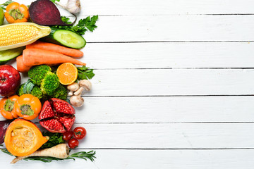 Fresh fruits and vegetables on white wooden background. Healthy food. Top view. Free copy space.