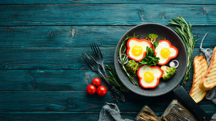 Fried egg with sweet pepper on a black plate. Top view. Free copy space.