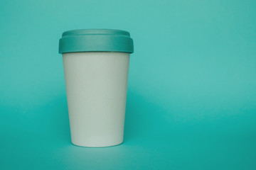 Reusable plastic free eco friendly bamboo cup for take away coffee on light blue background. Copy space. Bring your own cup concept. Zero waste, sustainable lifestyle.