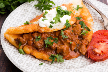 Potato pancakes with meat, vegetable, tomato and parsley