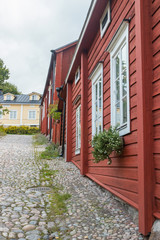 Fototapeta na wymiar Narrow street of Old Porvoo, Finland. Beautiful city autumn landscape with colorful wooden buildings.