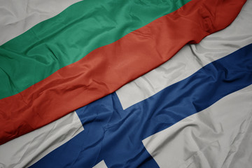 waving colorful flag of finland and national flag of bulgaria.