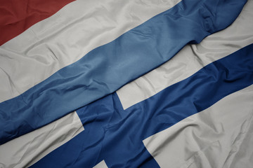waving colorful flag of finland and national flag of luxembourg.