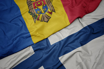 waving colorful flag of finland and national flag of moldova.