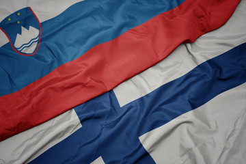 waving colorful flag of finland and national flag of slovenia.