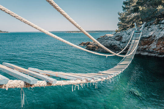 Rope bridge over a cliff in Punta Christo, Pula, Croatia - Europe. Travel photography, perfect for magazines and travel destination articles.