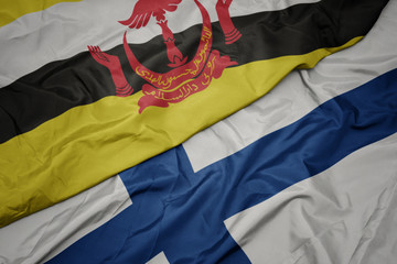 waving colorful flag of finland and national flag of brunei.