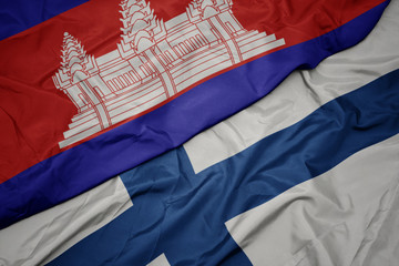 waving colorful flag of finland and national flag of cambodia.