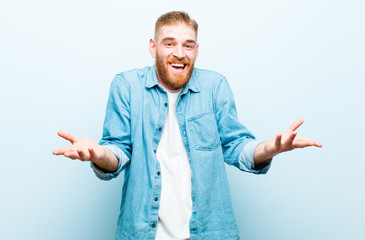 young red head man open-mouthed and amazed, shocked and astonished with an unbelievable surprise...