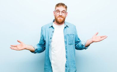 young red head man feeling puzzled and confused, unsure about the correct answer or decision,...