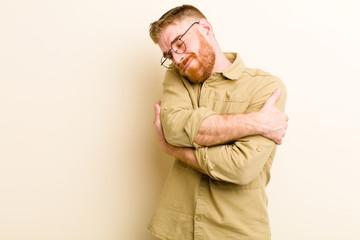 young red head man feeling in love, smiling, cuddling and hugging self, staying single, being...
