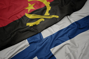 waving colorful flag of finland and national flag of angola.