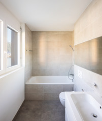 Fototapeta na wymiar Modern minimal bathroom with large tile bathtub
