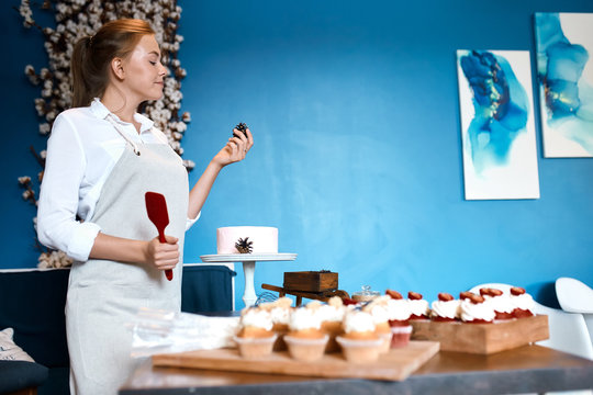 young talented cook checking pinecorn for cake, close up side view photo. copy space