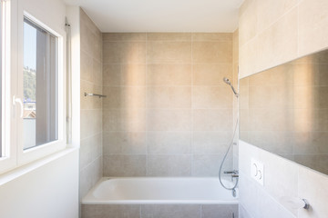 Modern minimal bathroom with large tile bathtub