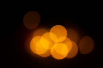 Out of focus yellow and warm lights on black background.
