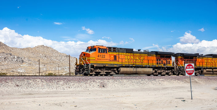 Freight BNSF train in California desert background, blue sky. US
