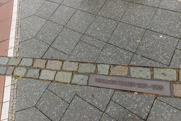 Fototapeta premium Plaque in the floor of Potsdamer Platz indicates the point where the famous Berlin Wall, Germany, passed