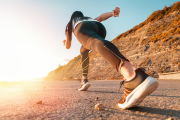 Sports and Jogging along the sea. The woman stands ready to run. In the background, the mountain...