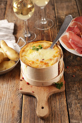 traditional french dish- cheese fondue with bacon, salami and potato- mont d'or