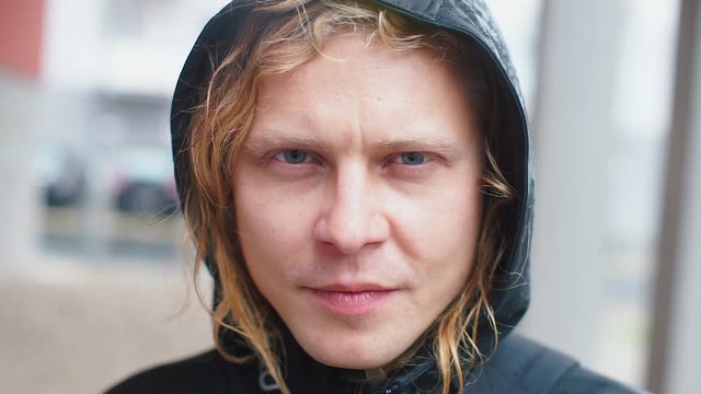 The guy puts on glasses on which raindrops