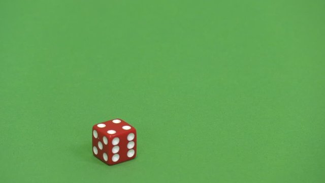Green screen shot of a red dice rolling 4