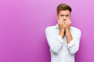 young man looking worried, anxious, stressed and afraid, biting fingernails and looking to lateral...