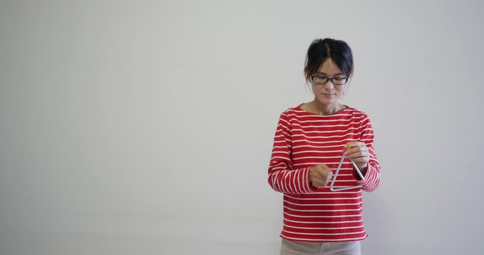 cute smiling Petite woman wearing fashion red striped clothes smiling and playing the triangle. natural makeup and normal behaviour. professional 4K shot of Chinese actress.
