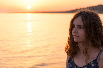 Fototapeta na wymiar portrait d'une belle jeune fille adolescente avec un coucher de soleil romantique