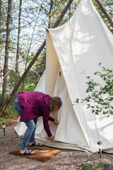 glamping trip - woman zipping canvas tipi in Montana