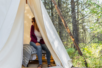 glamping trip - woman sitting in canvas tipi in Montana