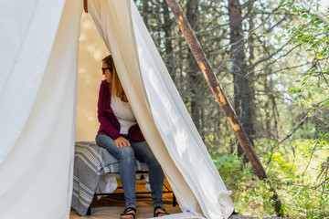 glamping trip - woman sitting in canvas tipi in Montana © David Prahl