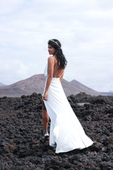 gorgeous bride is wearing a white dresson the island Lanzarote near volcano