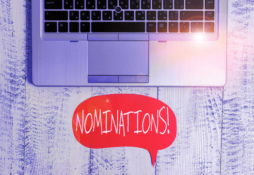 Writing note showing Nominations. Business concept for action of nominating or state being nominated for prize Close view open laptop speech bubble downwards lying vintage table