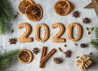 Ginger biscuits of the form of numbers and 2020 new year ginger cookies on grey background. Top view. Seasonal New Year's attributes