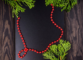 Christmas Border. Fir tree branches on dark wooden background. Top view. Copy space