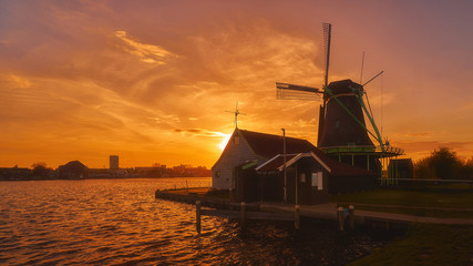 Dutch windmill near the lake during sunset