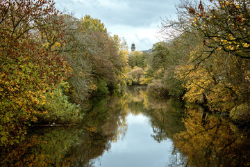 The River Aire wends its way through autumn trees towards the historic model village of Saltaire in Yorkshire