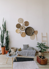 Boho style, minimal home interior design. Decorative straw plates on the wall. Exotic interior.