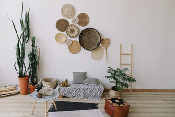 Boho style, minimal home interior design. Decorative straw plates on the wall. Exotic interior.