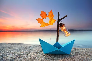 Selbstklebende Fototapeten Papierboot mit Herbstblatt und Laterne © Jenny Sturm
