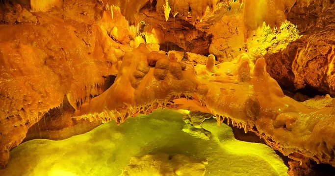 Inside of limestone stalactite cave with an underground lake in Portugal, 4K