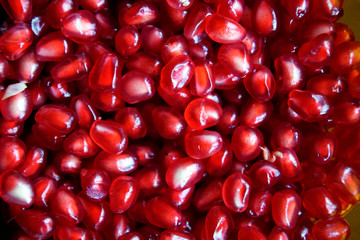 Refined garnet grains of ruby color. Juicy beautiful fruit. Background texture. Close-up.
