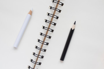 white and black pencil on Notepad, business concept, top view, copy space