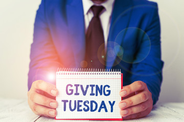 Word writing text Giving Tuesday. Business photo showcasing international day of charitable giving Hashtag activism Man holds empty paper with copy space in front of him Space