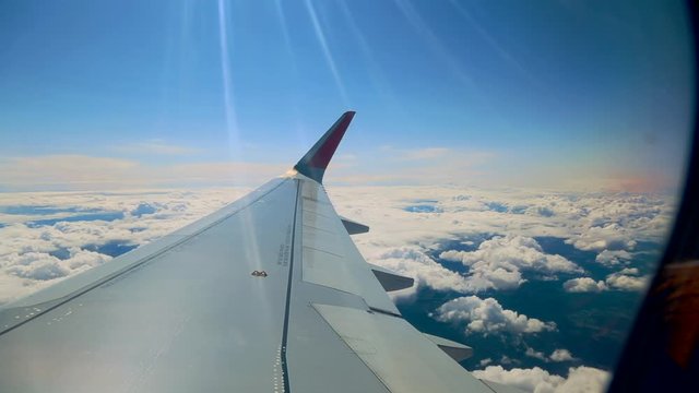 Beautiful cloud and wing of airplane from window with a nice blue sky
