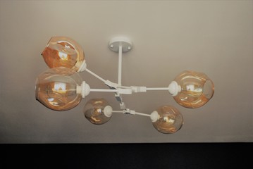 Chandelier molecule for lighting a small room. Beige shades on the ceiling chandelier.